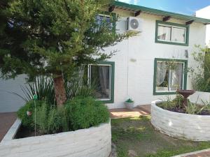 una casa con un árbol en un patio en Departamento para cinco, full equipado en Colonia del Sacramento