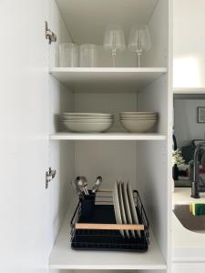 a kitchen pantry with plates and bowls and utensils at Sky View 1B1B APT in the CBD in Melbourne