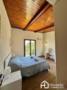 a bedroom with a large bed with a wooden ceiling at Lisa's country house in Lefkandi Chalkidas