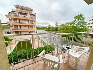 einen Balkon mit 2 Stühlen und ein Gebäude in der Unterkunft North Beach Apartments in Primorsko