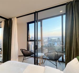a bedroom with a bed and a large window at Sky View 1B1B APT in the CBD in Melbourne +10 photos