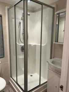a glass shower in a bathroom with a sink at Windermere lodge,sleeps 6 in Windermere