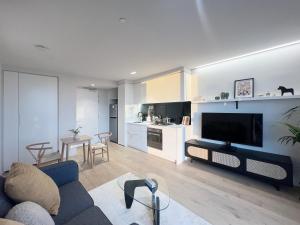 a living room with a blue couch and a kitchen at Sky View 1B1B APT in the CBD in Melbourne