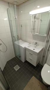 Un baño con ducha, lavabo y espejo. en City center apartment with late check-in and -out, en Pori