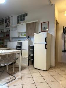 a kitchen with a white refrigerator and a table at The fairy house in Capannori