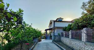 a house with a fence next to a driveway at Wooden Guest House in Bamatat