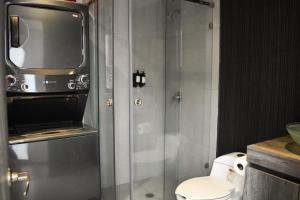 ein Bad mit einem WC und einem TV darüber. in der Unterkunft Moderno Departamento con terraza pegado a la condesa in Mexiko-Stadt