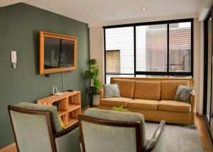 sala de estar con sofá, sillas y espejo en Moderno Departamento con terraza pegado a la condesa en Ciudad de México