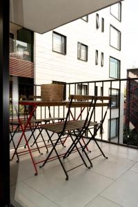 einen Tisch und Stühle auf dem Balkon in der Unterkunft Moderno Departamento con terraza pegado a la condesa in Mexiko-Stadt
