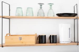 a wooden shelf with glass items on it at Élégante chambre avec salle de douche privative in Montivilliers +14 photos