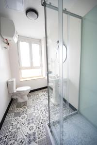 a bathroom with a toilet and a glass shower at Élégante chambre avec salle de douche privative in Montivilliers