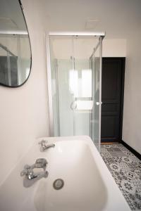 a white bathroom with a sink and a mirror at Élégante chambre avec salle de douche privative in Montivilliers