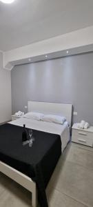 a white bedroom with a bed with a glass of wine at Room's Stromboli in San Ferdinando