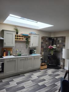 cocina con armarios blancos y suelo de baldosa en Lissadell Lodge en Wexford