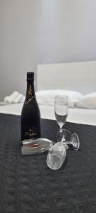 - une bouteille de vin et un verre sur une table dans l'établissement Room's Stromboli, à San Ferdinando