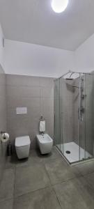 ein Bad mit einer Dusche, einem WC und einem Waschbecken in der Unterkunft Room's Stromboli in San Ferdinando