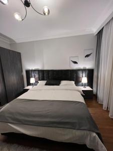 een slaapkamer met een groot bed en 2 lampen bij Madinty vg1 مجموعة ٨ فيلا ٤١ مدينتى villa in Madinaty