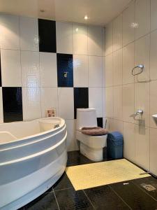 y baño con bañera, aseo y lavamanos. en Fully furnished 135m2 apartment with 4 rooms in Crystal town near by Dunjingarav Market, en Ulán Bator