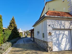 een wit gebouw met een garage naast een oprit bij Ginger House Apartment in Keszthely