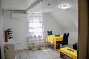 a room with a table with a yellow table cloth at F&F Suites Ilsfeld - 3 Zimmer DG schickes Apartment - Zentral mit kostenfreien Privatparkplätzen und WLAN in Ilsfeld