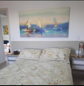 1 dormitorio con 1 cama con una pintura en la pared en Seu lar na praia das Toninhas em Ubatuba, en Ubatuba