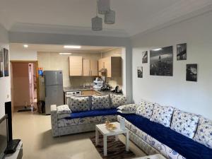 a living room with a couch and a kitchen at Prestigieux Appartement à Marina Assilah Golf in Asilah