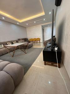 - un salon avec un canapé et une télévision sur une table dans l'établissement Islane vue piscine, à Agadir