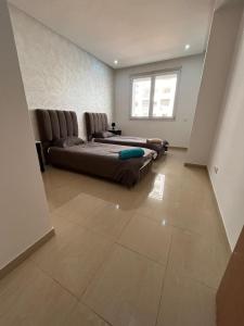 une chambre avec un lit, un canapé et une fenêtre dans l'établissement Islane vue piscine, à Agadir 37 autres photos