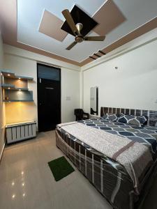 um quarto com uma cama e uma ventoinha de tecto em Jadoon Homestay near Prem Mandir em Vrindāvan