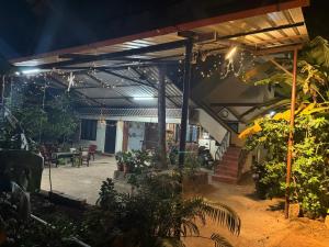 eine Terrasse in der Nacht mit Licht und Pflanzen in der Unterkunft KENSON'S INN in Mangaluru