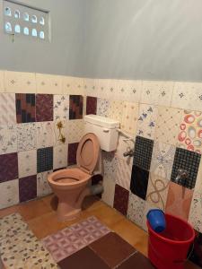 KENSON'S INN في منغالور: حمام به مرحاض وبلاط على الحائط