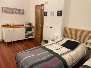 a bedroom with a large bed and a kitchen at Las 5 Bes- Estudio bed&breakfast in Valladolid