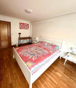 a bedroom with a white bed with a red blanket at Habitaciones Hondar-Gain 10 in Zumaia +9 photos