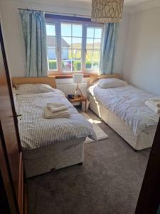 En eller flere senger på et rom på Coastal home in Luskentyre