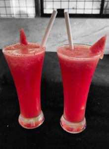 dos vasos de bebidas rojas con pajitas en una mesa en The Royal Island, en Munroe Island