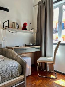 a bedroom with a chair and a desk and a window at AL Barbinha in Faro