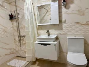 a white bathroom with a sink and a toilet at Royal Cottages in Kazbegi +67 photos