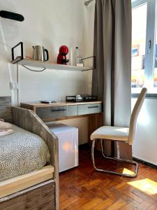 a bedroom with a bed and a chair and a desk at AL Barbinha in Faro