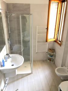 ein Bad mit einer Dusche, einem Waschbecken und einem WC in der Unterkunft Casa Berso' in Marina di Cecina