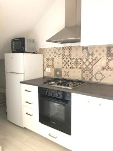 een keuken met een zwarte kachel en een koelkast bij Casa Berso' a Marina di Cecina by Zoom In Earth in Marina di Cecina +15 foto's