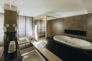 a bathroom with a large tub and a sink at Golden Tulip Natal Ponta Negra in Natal