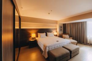 ein Hotelzimmer mit einem Bett und einem Stuhl in der Unterkunft Golden Tulip Natal Ponta Negra in Natal