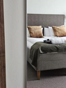 a reflection of a bedroom with a bed and a mirror at Hotel Skansen in Färjestaden