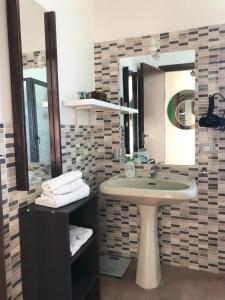 un bagno con lavandino e specchio di Casa Vacanza L'ulivo a Paterno