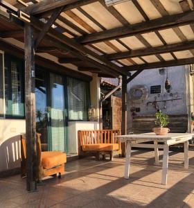 un patio con tavolo, sedie e panca di Casa Vacanza L'ulivo a Paterno Altre 4 foto