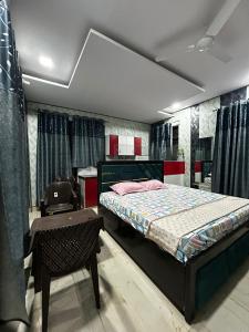 a bedroom with a bed and a table and a chair at Jadoon Homestay near Prem Mandir in Vrindāvan