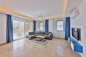 a living room with a couch and a tv at Villa Albedo Blue in Kaş