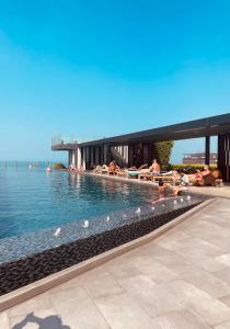 a swimming pool with people laying in the water at The base Central Pattaya 100 by Numam in Pattaya Central +46 photos
