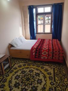 拉瓦格拉Hotel Rainbow Regency Ravangla South Sikkim的一间卧室设有床、窗户和地毯。 更多37张照片