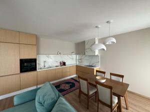 a living room with a table and a kitchen at The Boulevard Bliss in Tirana